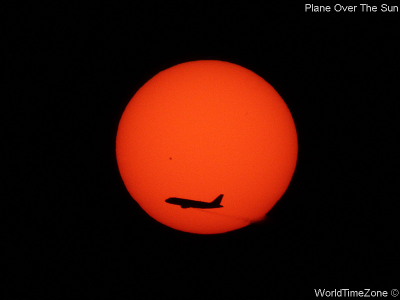 Plane over the Sun by worldtimezone